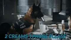 Un perro policía metiendo un teléfono celular en una taza de café.